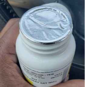 Hand holding sealed medication bottle